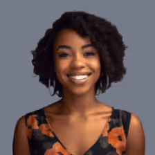 Smiling woman with short curly hair wearing a black top with orange floral pattern.